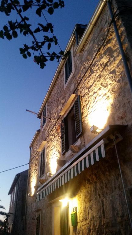 un edificio de piedra con luces en el lateral. en Buena Vis-ta Apartments with the Sea View, en Vis