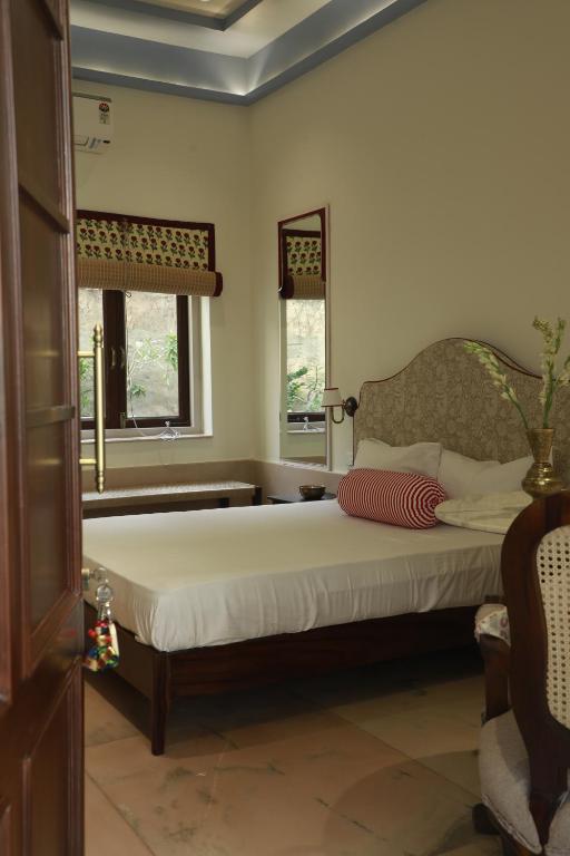 Un dormitorio con una cama grande y dos ventanas. en Kasumal, en Jaipur