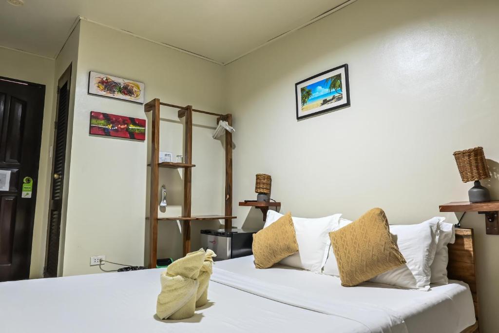 a bedroom with a bed with white sheets and pillows at Bulskamp Inn in El Nido