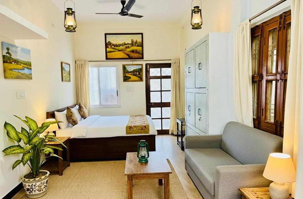 ein Schlafzimmer mit einem Bett, einer Couch und einem Tisch in der Unterkunft Ahluwalias Farmstay in Mandlā