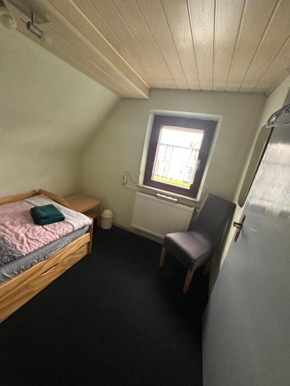 a small room with a bed and a chair at Corner Haus RM1 in Schnaittach