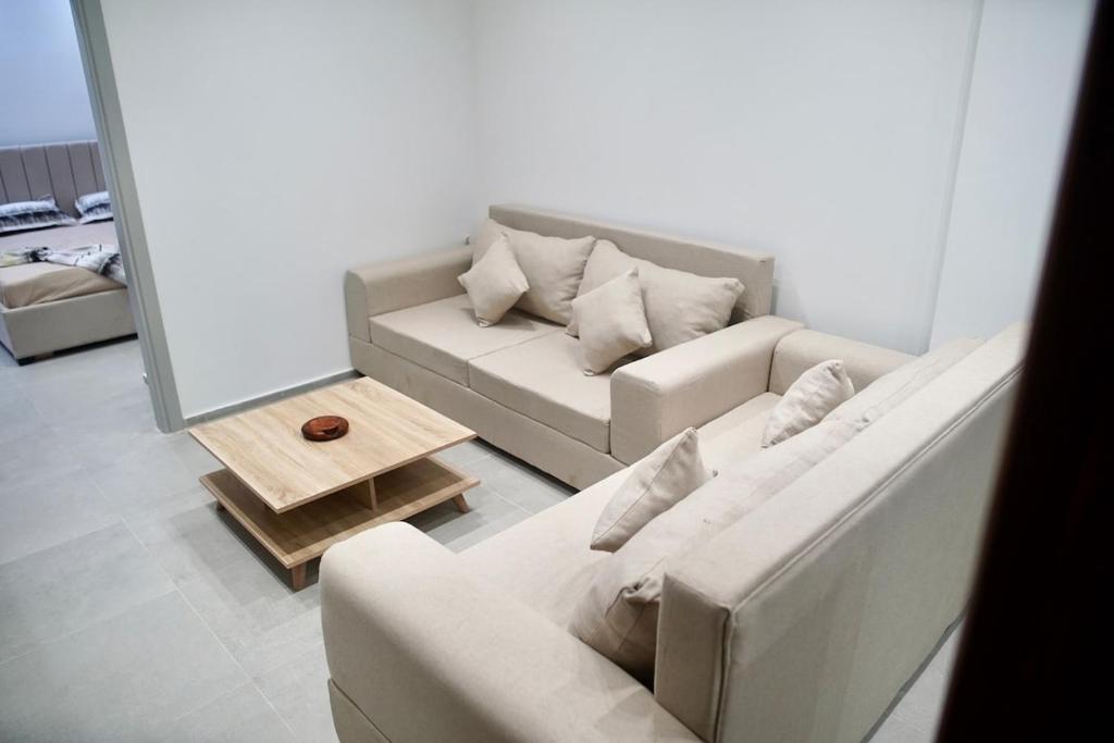 ein Wohnzimmer mit zwei weißen Sofas und einem Tisch in der Unterkunft Charming S1 cozy modern and bright in Mahdia