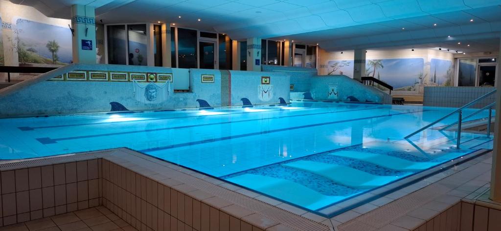 a large swimming pool with blue lighting in a building at Premium Apartment Wohlfühl-Oase mit Pool und Sauna in Sankt Englmar