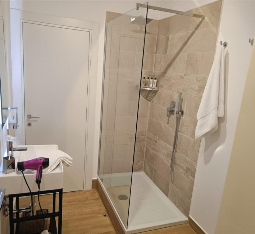a bathroom with a shower with a glass door at Etna Charme Guest House in Belpasso
