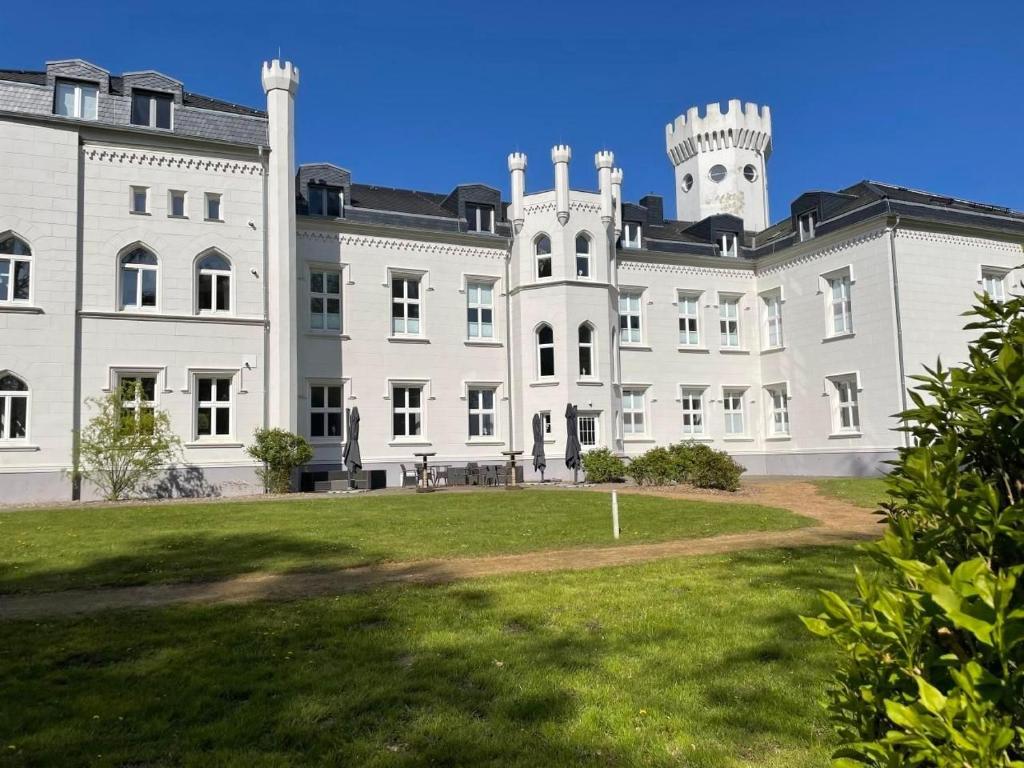 a large white building with a tower on top at Weisses Traumschloss An Der Ostsee in Hohendorf