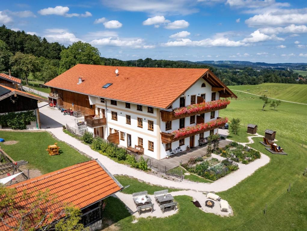 eine Luftansicht eines Hauses mit orangefarbenem Dach in der Unterkunft Schleipfnerhof Urlaub auf dem Bauernhof in Bernau am Chiemsee