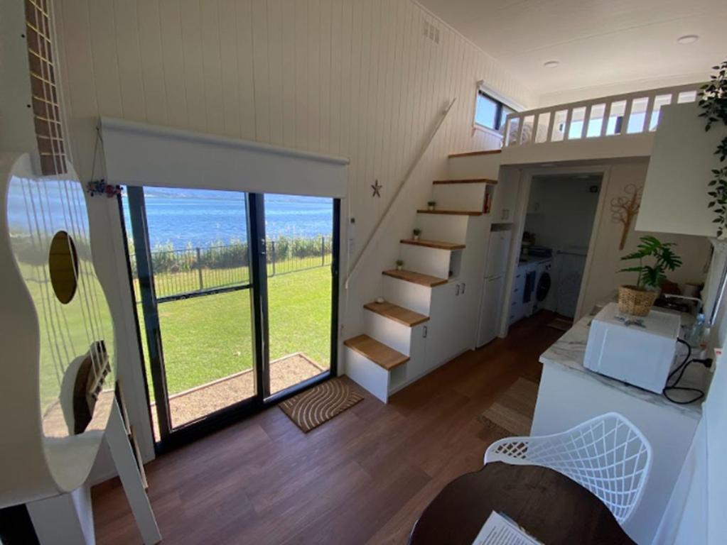 a room with a staircase and a stair case in a house at Cudgeree Tiny Stay in Windang