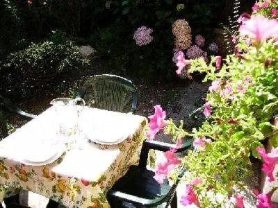 a table and chairs in a garden with flowers at Wohnung Oleandro In Miasino in Miasino