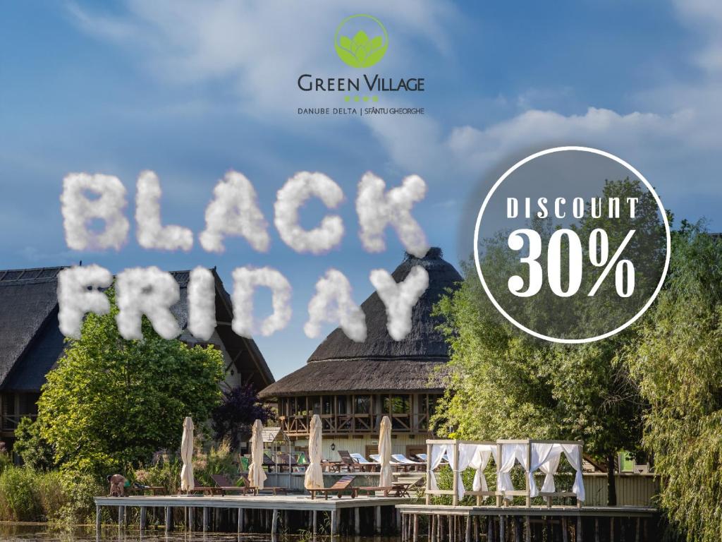 a sign that reads green village black resort discount at Green Village Resort in Sfântu Gheorghe