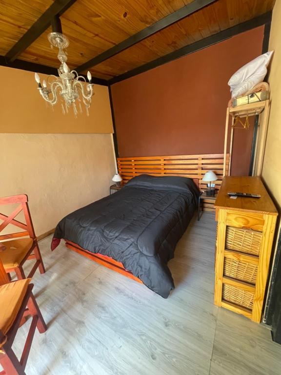 La Cabaña في سانتا كلارا ديل مار: غرفة نوم بها سرير كبير وثريا