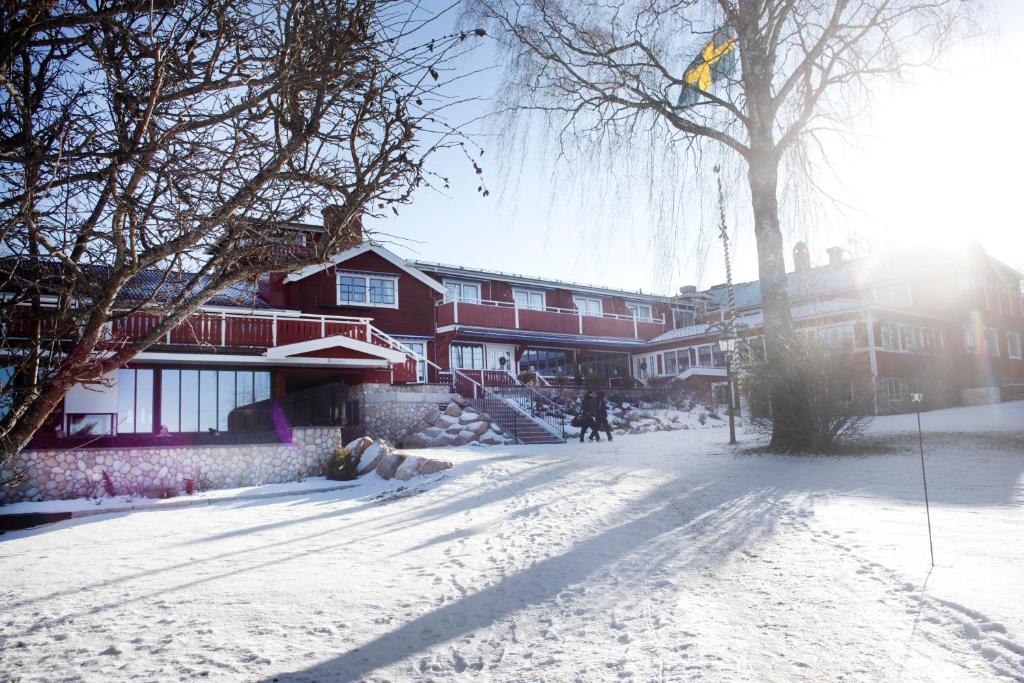 une rue enneigée devant un bâtiment dans l'établissement Åkerblads Hotell Gästgiveri Spa, à Tällberg