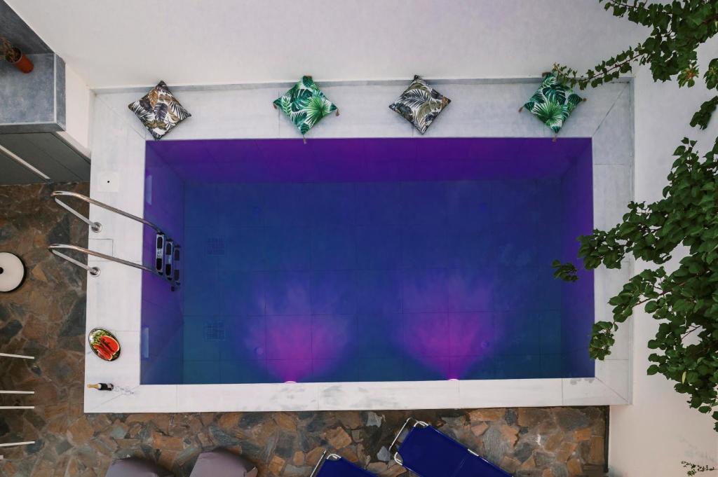 un grand écran de télévision sur un mur de pierre avec quatre étoiles dans l'établissement Koskinou Escape Villa, à Koskinou