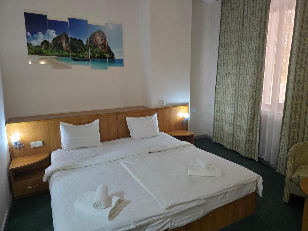 - une chambre avec un grand lit et 2 serviettes blanches dans l'établissement Hotel Expo, à Yunusobod