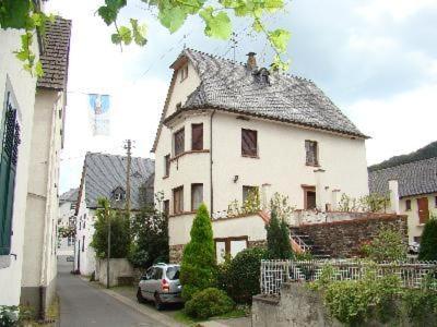 a white house with a car parked in front of it at Ferienhaus Altes Winzerhaus In Mesenich in Mesenich