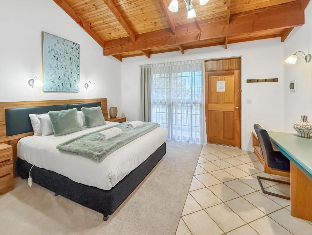 Un dormitorio con una cama grande y un escritorio. en Coonawarra Place Motor Inn, en Coonawarra