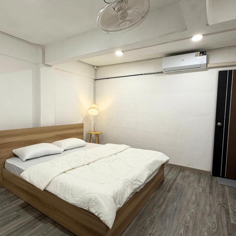 een slaapkamer met een groot bed en een plafondventilator bij Box me in Bangkok