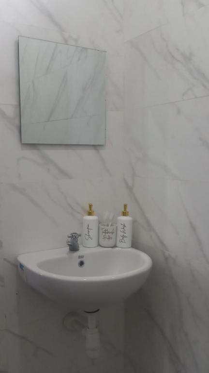 ein weißes Waschbecken in einem Badezimmer mit einem Spiegel in der Unterkunft Villa Kopi Klotok in Pasuruan