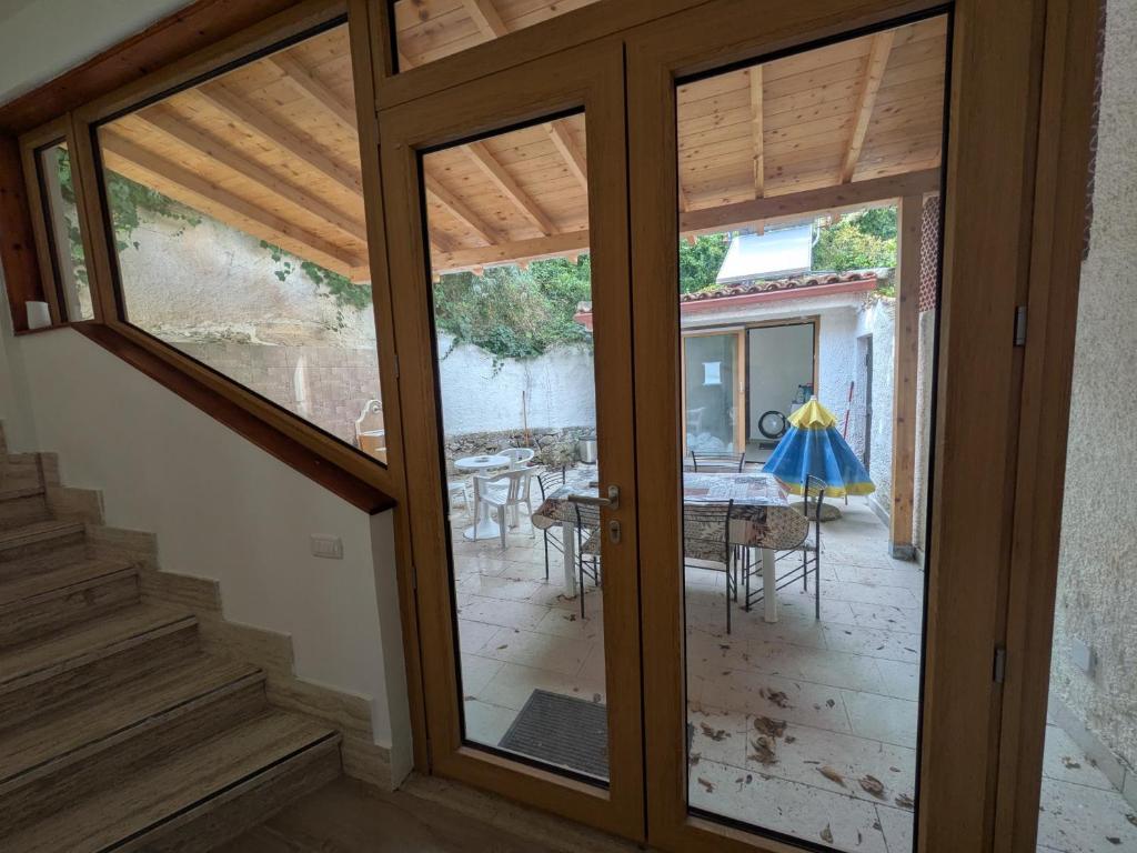 eine Glasschiebetür, die auf eine Terrasse mit einem Tisch führt in der Unterkunft Maison Lido in Fontane Bianche