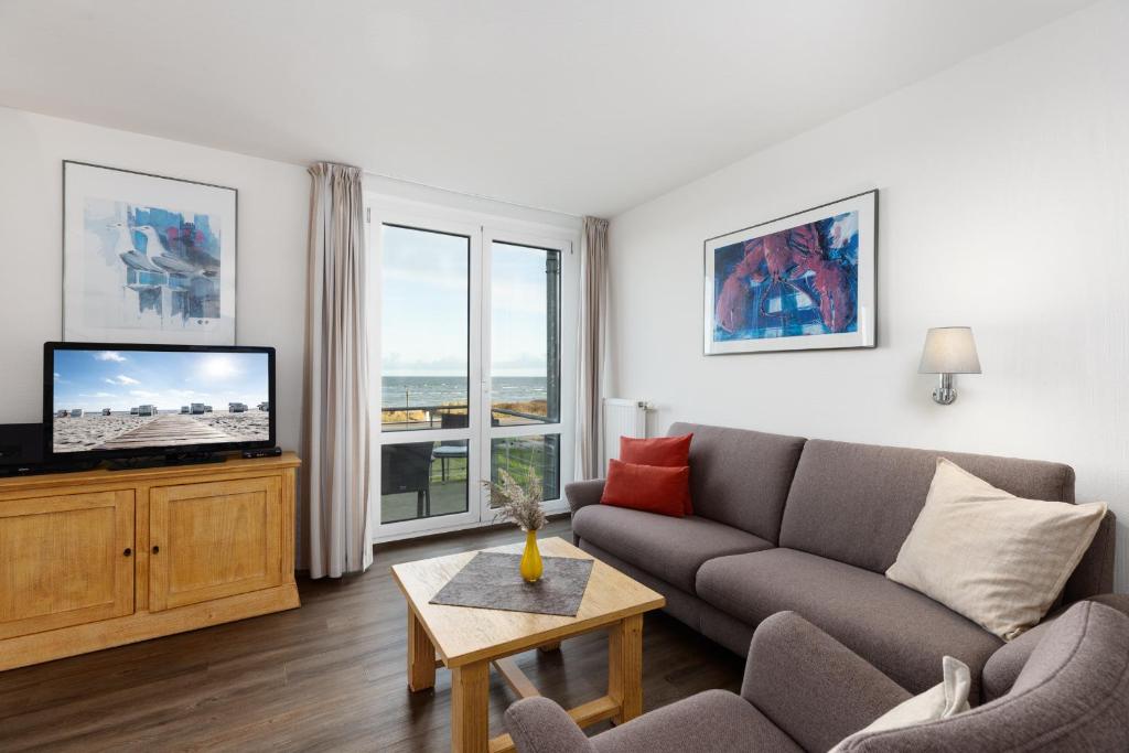 a living room with a couch and a tv at Dorfring 36 Seeadler in Stein