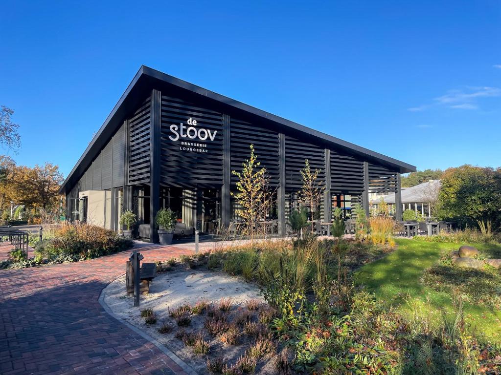 un bâtiment noir avec un panneau sur son côté dans l'établissement Kampeerdorp de Zandstuve - Kindvriendelijke Vakantiepark, à Rheeze
