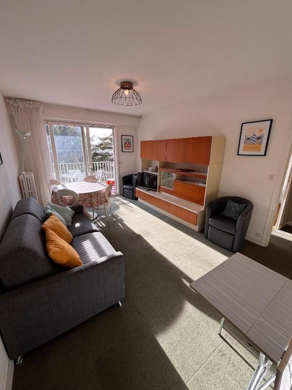 ein Wohnzimmer mit Sofa und Tisch in der Unterkunft Ti Hou - T2 600 m plage - Lajarrige in La Baule-les-Pins