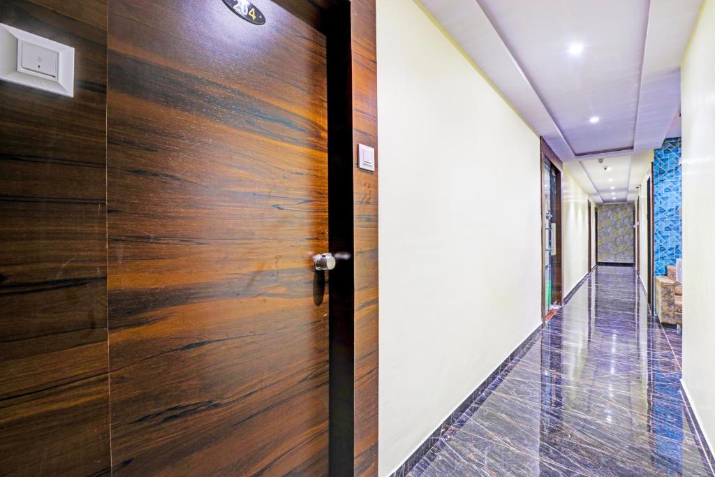 a wooden door in the hallway of a house at Hotel O Golden in Vadodara