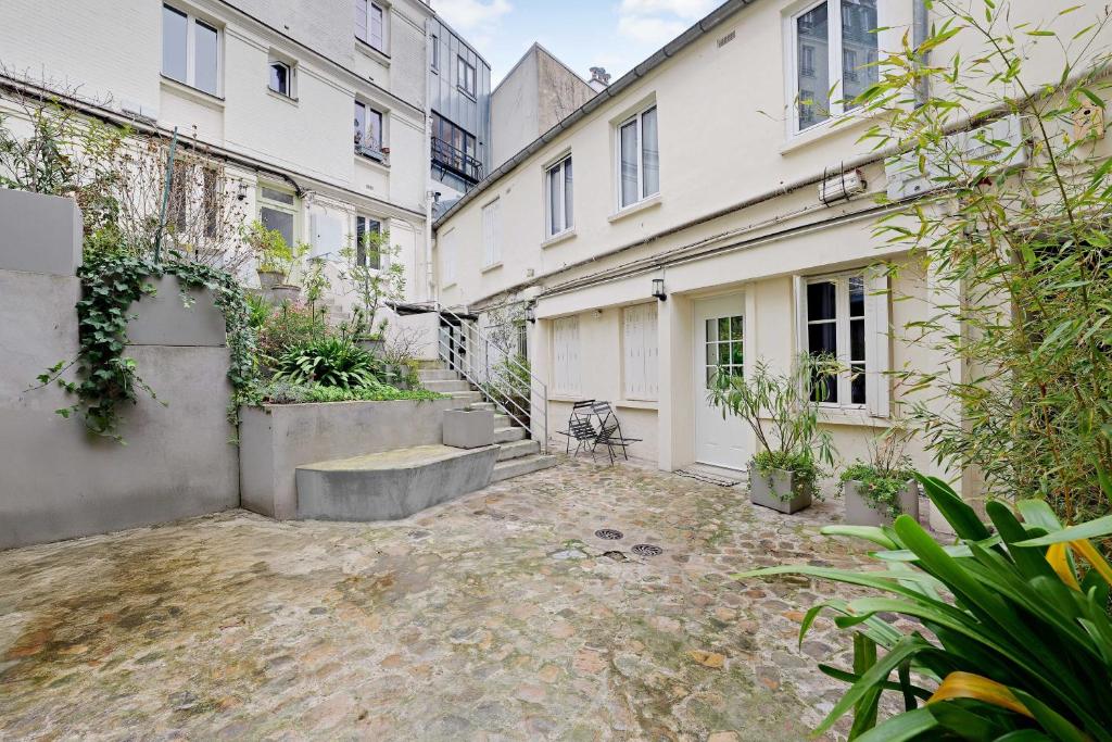 an empty courtyard in front of two buildings at Cozy Studio 2P – Montmartre in Paris
