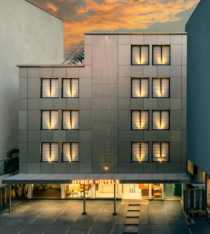 a facade of a building with lit windows at Hyber Hotel's- Gachibowli in Hyderabad