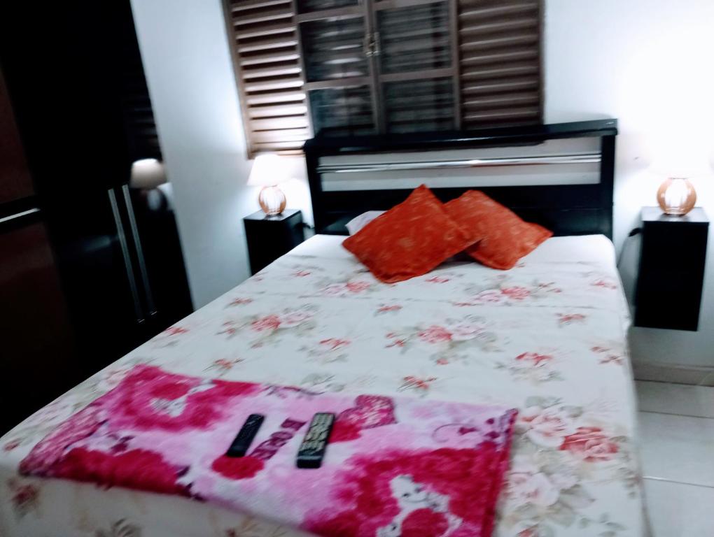 a bedroom with a bed with red pillows on it at VERTT Engenharia in Campo Grande