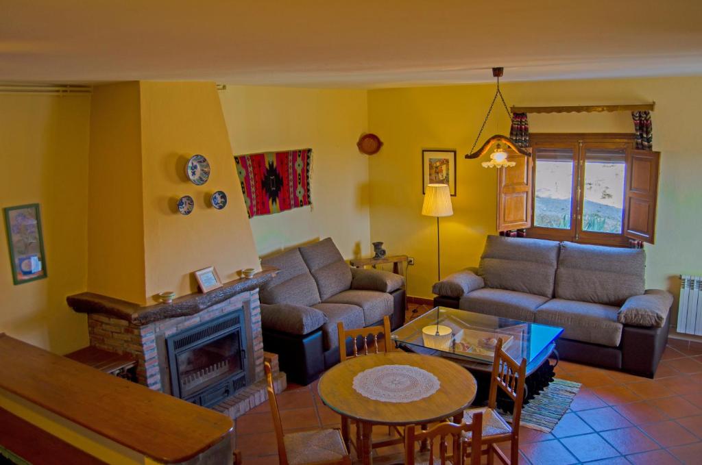 a living room with a couch and a fireplace at Casa Número 5 in Válor