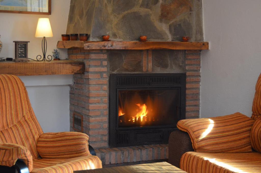 a living room with a fireplace with a fire in it at Casa Número 2 in Válor