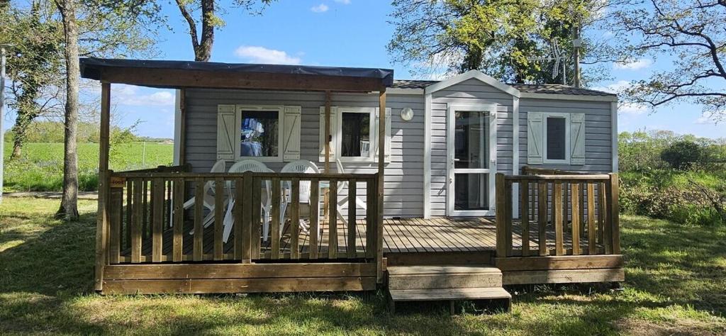 a tiny house with a porch and a deck at Mobil Home EDEN2 en Vendée 6 pers 3chbr in La Boissière-de-Montaigu