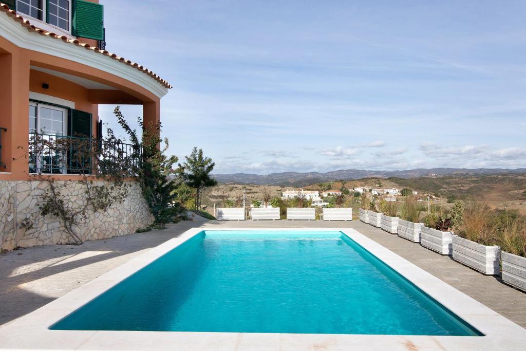 a swimming pool in the backyard of a house at Vila Picota in Cerro da Zorra