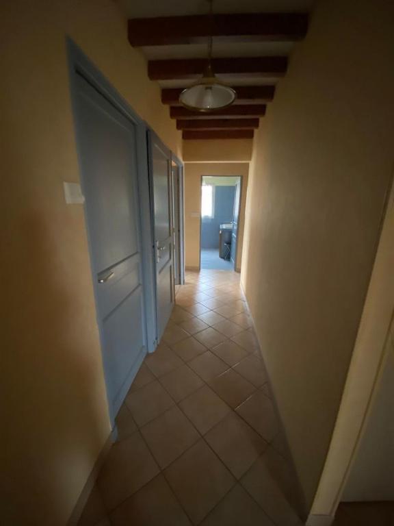 a hallway with an open door to a room with a tile floor at Le clos des érables in Montesquieu
