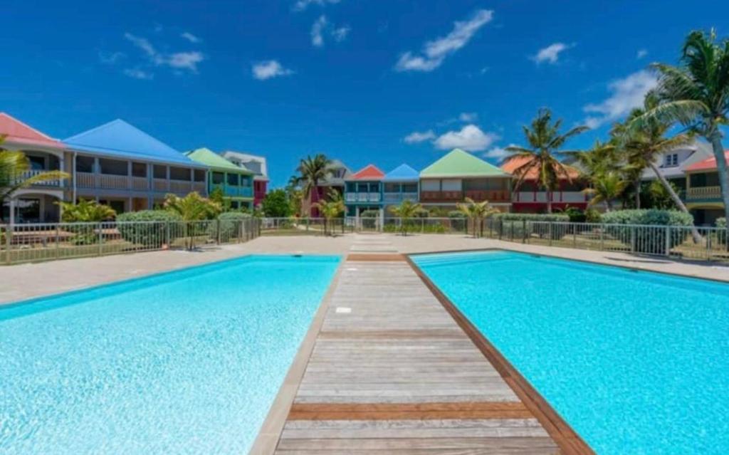 a swimming pool at a resort with blue water at Sand and Style, Baie Orientale in Saint Martin