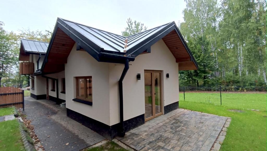 une petite maison avec un toit en métal dans l'établissement Miejscówka Werlas, à Polańczyk