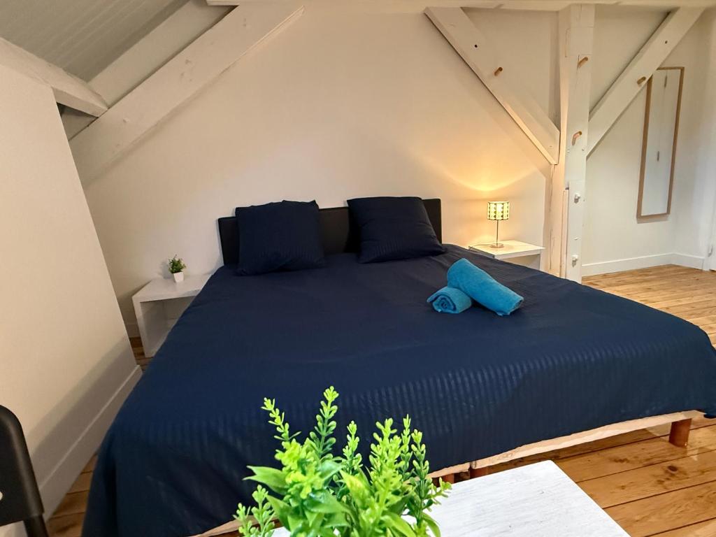 a bedroom with a blue bed in a attic at Studio Rénové - Cœur de Ville WIFI in Dreux