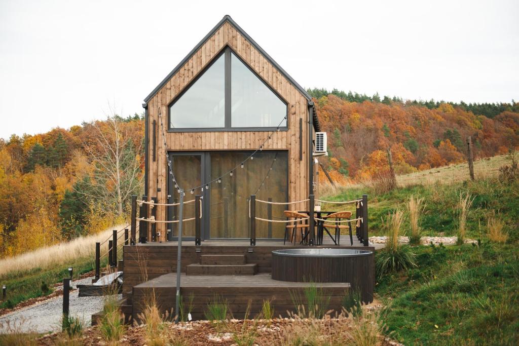 LutomiaOko na Sowie的一座小木结构建筑,在山坡上设有窗户