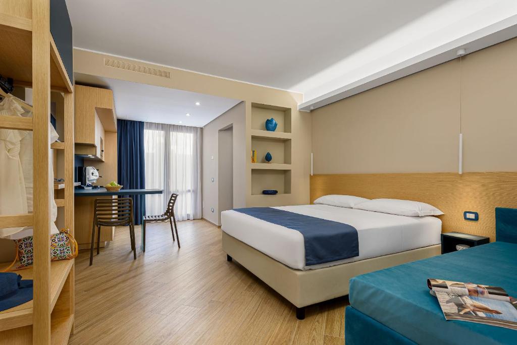 a hotel room with a bed and a desk at Hotel Calliope in San Vito lo Capo