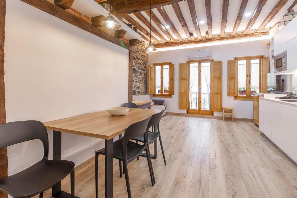 une cuisine et une salle à manger avec une table et des chaises en bois dans l'établissement El Patio de Vespasiano- San Juan- vistas al ayuntamiento junto al puerto, à Castro Urdiales