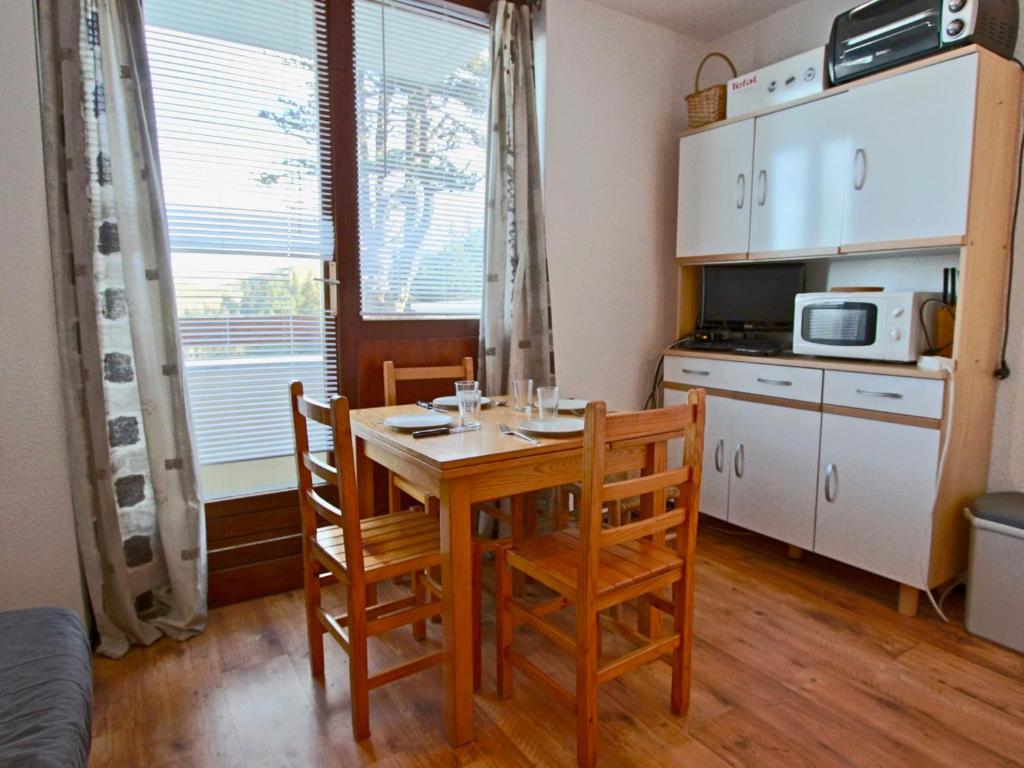 a kitchen with a table and chairs in a room at Studio cosy 3 places au pied des pistes, animaux acceptés - FR-1-340-124 in Chamrousse