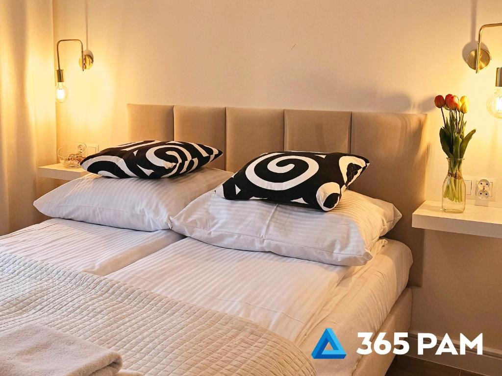 two pillows on a bed in a bedroom at 365PAM - Apartament Dobra Aura w Summer Lofts in Ustronie Morskie