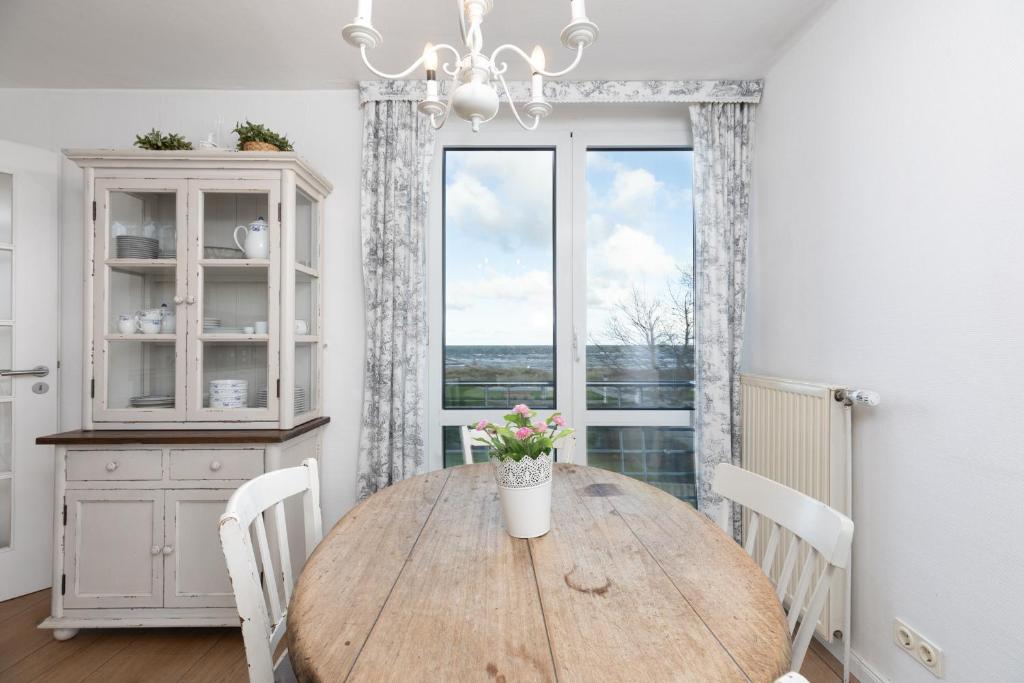 ein Esszimmer mit einem Holztisch und einem Fenster in der Unterkunft Dorfring 36 Albatros in Stein