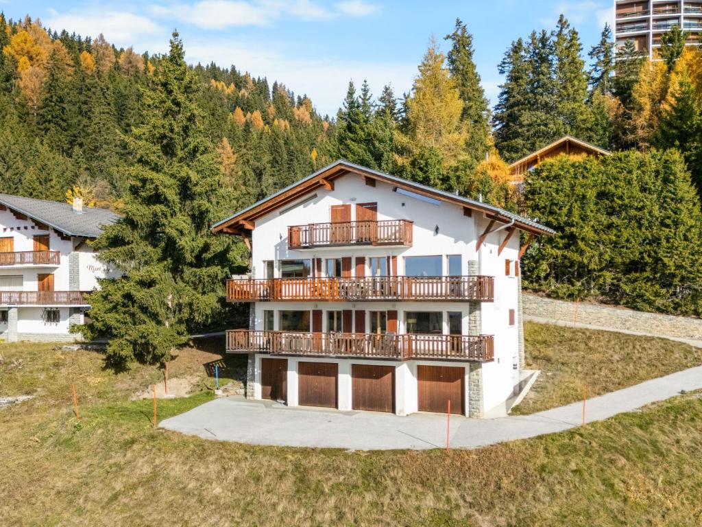 an apartment building with a balcony and trees at Apartment Les Aiguilles Vertes Rez inférieur by Interhome in Crans-Montana