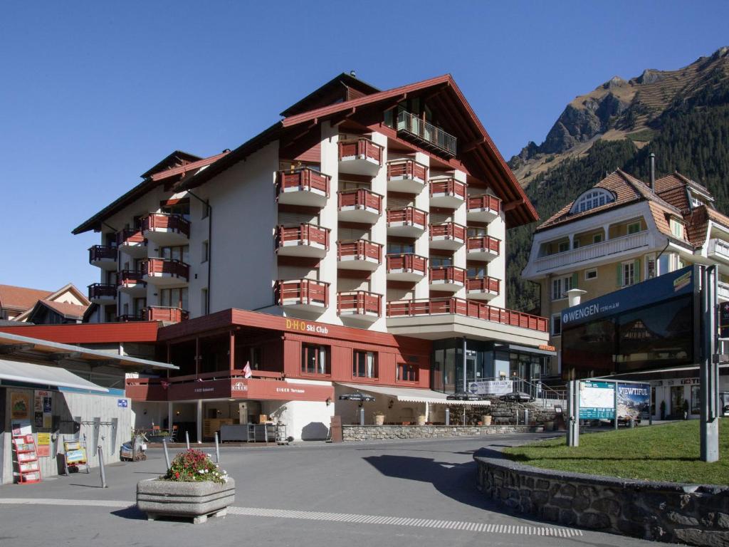 a large apartment building in the middle of a street at Apartment Eiger Residence Apt-A-425 by Interhome in Wengen