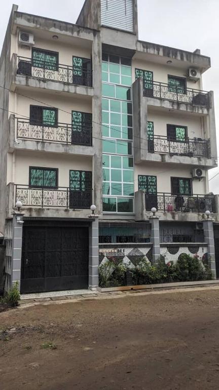 Un edificio con balcones a los lados. en MB Suite Cogefar, en Douala
