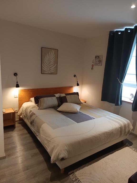 a large bed in a bedroom with a window at Monts et Rêves in Ramonchamp