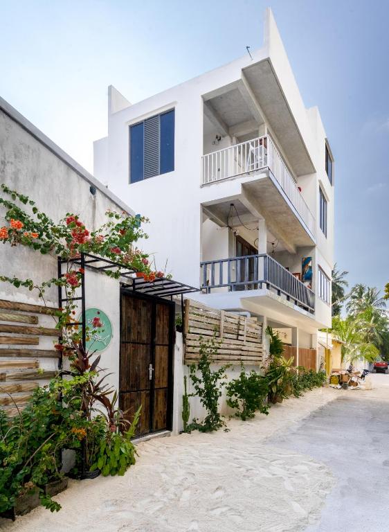 Un edificio blanco con balcón y flores. en Rasdu View Inn, en Rasdu