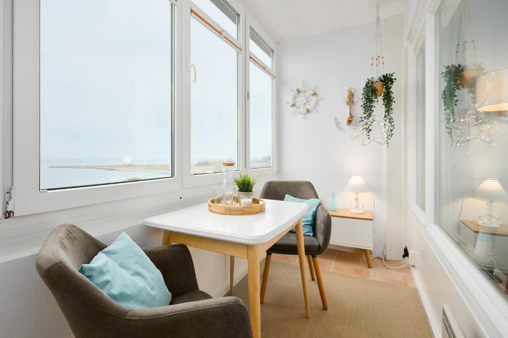 a room with two chairs and a table and two windows at Strandbude in Laboe