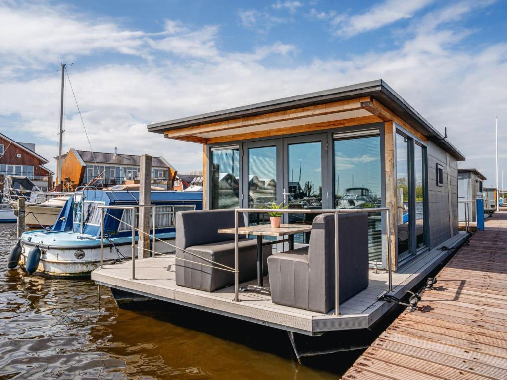 une petite maison sur un quai au bord de l'eau dans l'établissement Holiday Home De Meerparel-1 by Interhome, à Uitgeest